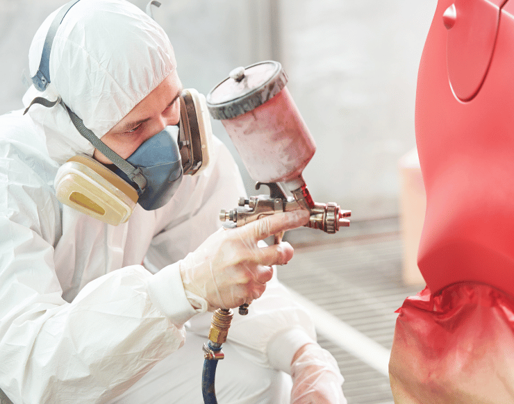 Technician performing automotive painting in Malden using a spray gun on a car